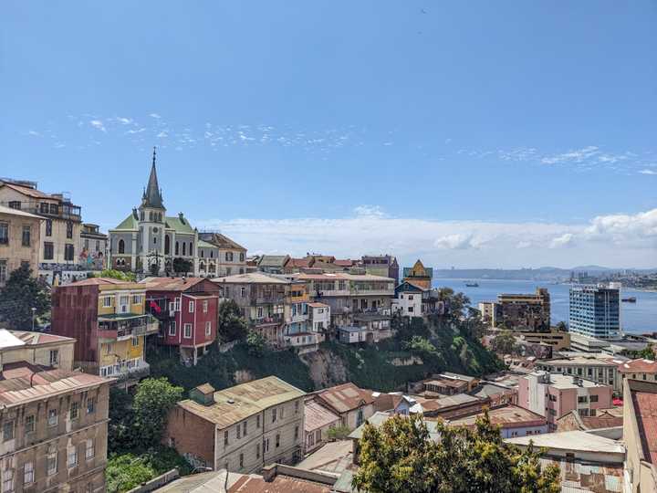 View of the hills of Valparaiso with many eclectic colourful buildings and the bay in the distance